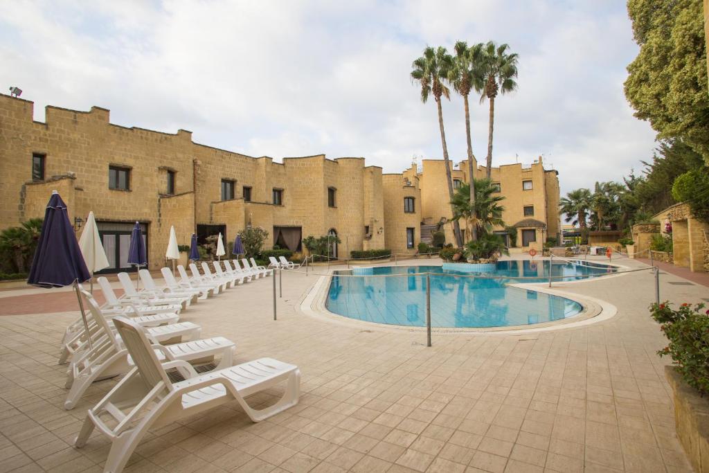 莫斯村莫塞大酒店的一个带游泳池和椅子的度假胜地和一座建筑