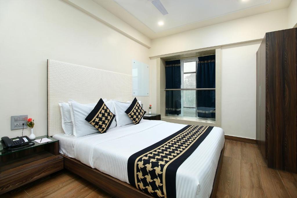 孟买Hotel Mumbai House Juhu, Santacruz West, Mumbai的一间卧室设有一张大床和一个窗户。