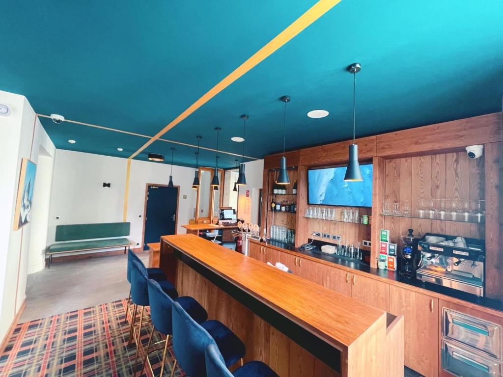 夏蒙尼-勃朗峰Hotel La Verticale的一间酒吧,位于蓝色天花板的房间内