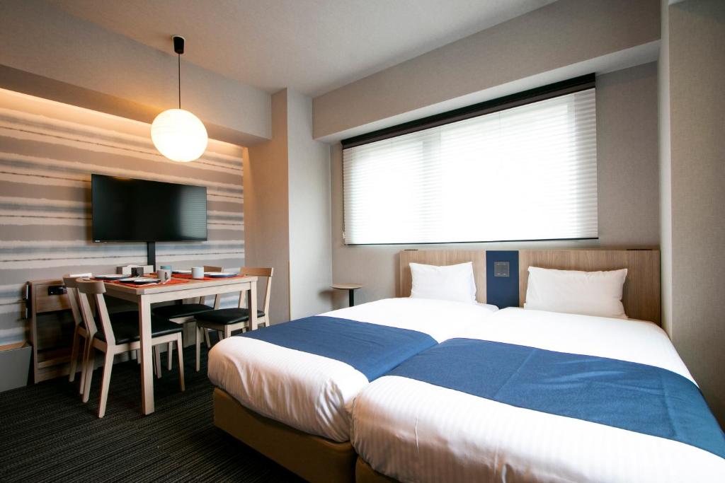 东京Minn Nishi-Kasai的酒店客房配有一张床和一张带电脑的书桌