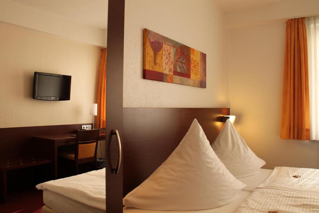 汉诺威豪斯斯帕库勒伽尼酒店的一间酒店客房,设有两张床和电视