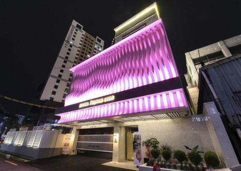 釜山Hotel French Code的一座晚上有紫色灯饰的建筑