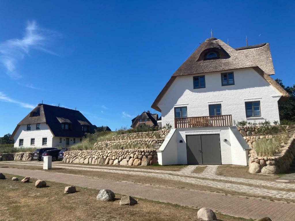 兰图姆Rantum Dorf - Ferienappartments im Reetdachhaus 3 & 4的一座带茅草屋顶的大型白色房屋