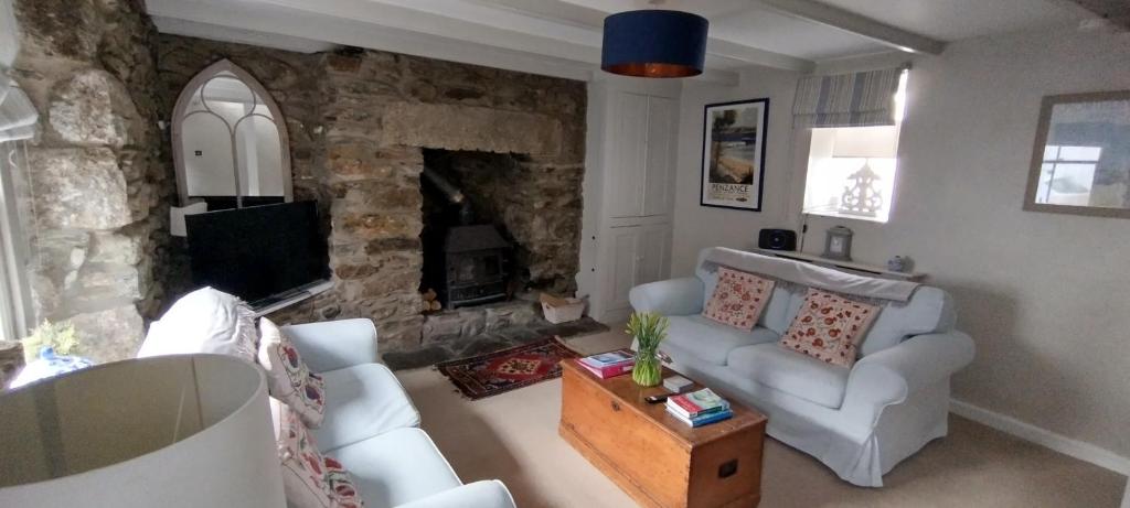 赫尔斯顿Samphire Cottage的带沙发和壁炉的客厅