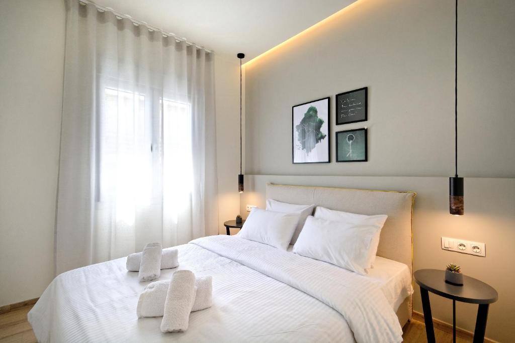 雅典Eos Residence的卧室配有白色的床和2条毛巾