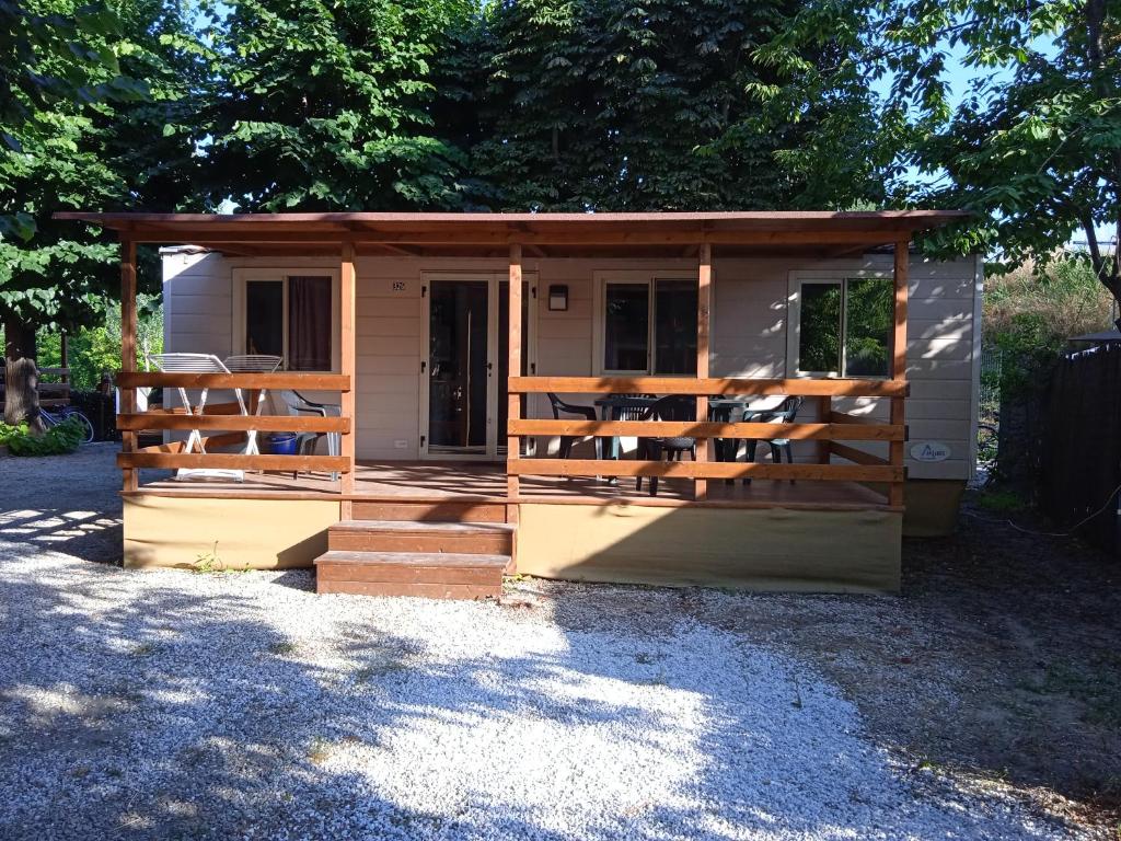 阿梅利亚Mobile home Comfort Ameglia - Camping River- 326- 6 pers的一个小房子,设有门廊和栅栏