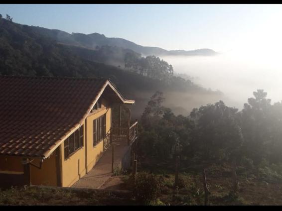阿尤鲁奥卡Chalé Sabiá的山丘上的房子,享有雾 ⁇ 的山谷景色