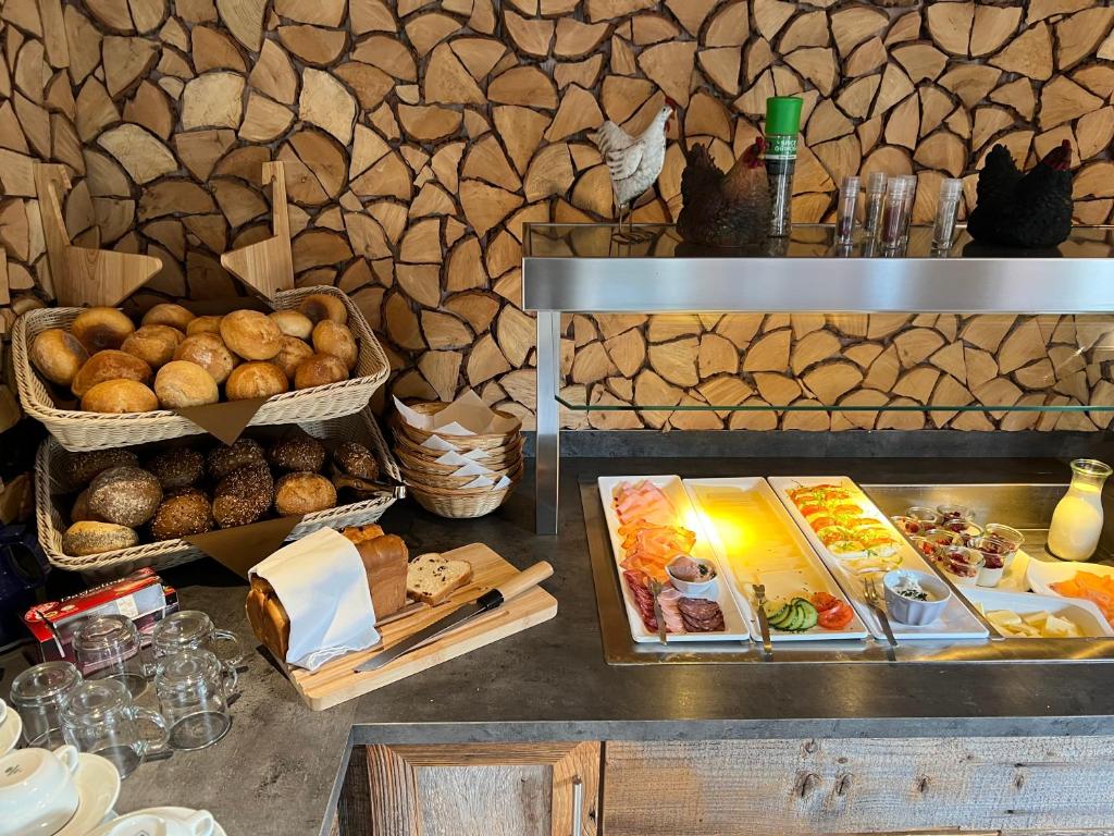 温特贝格温特贝格林尼普拉兹贝格酒店的自助餐,包括面包和其他食物在餐桌上