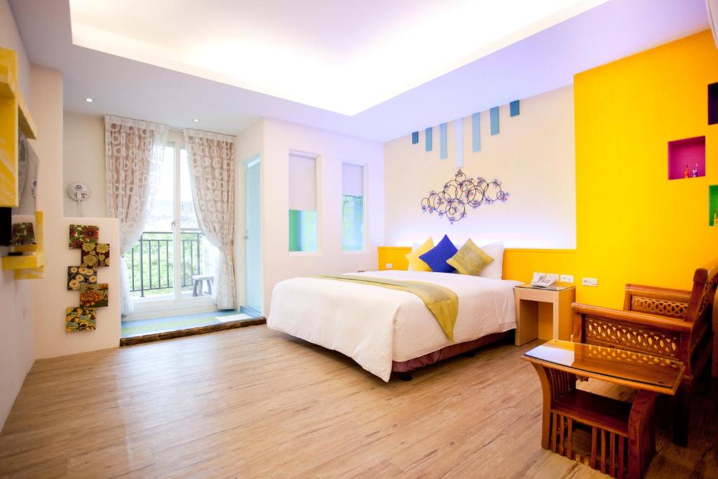 垦丁大街垦丁长禧旅店的一间卧室设有一张床和黄色的墙壁