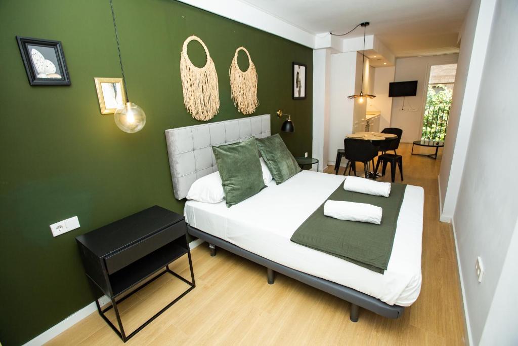 瓦伦西亚Total Valencia Torres de Quart的一间卧室设有一张床和绿色的墙壁