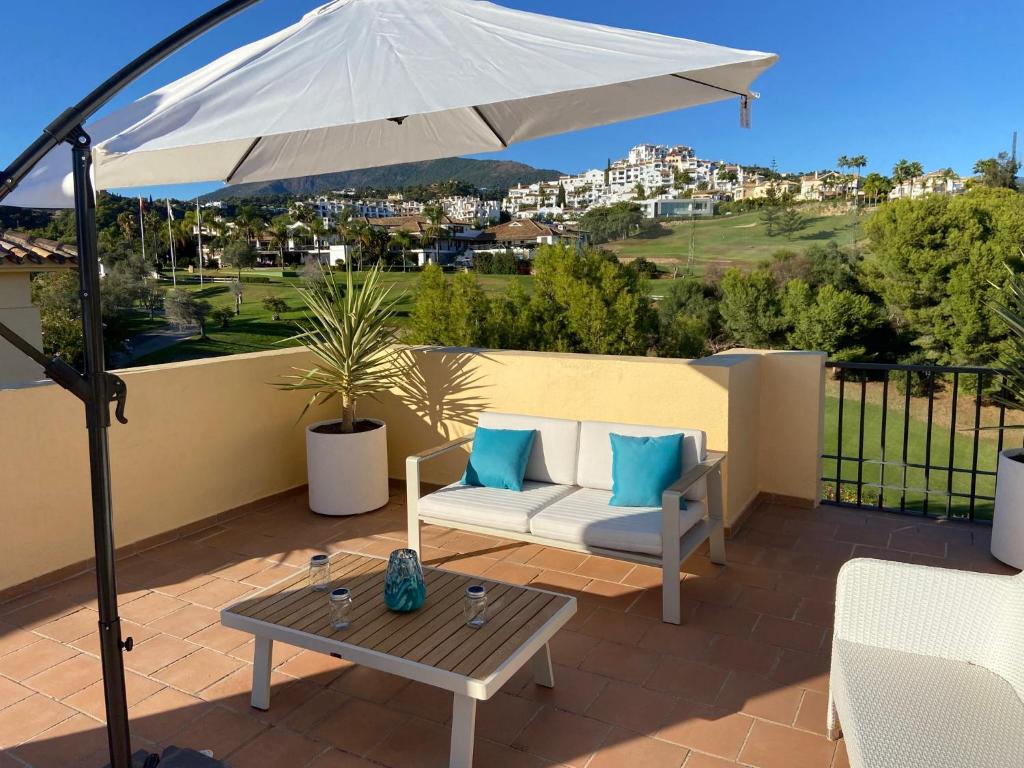 贝纳阿维斯Huge Rooftop Solarium With See View - 3 rooms的庭院配有白色遮阳伞和桌子。