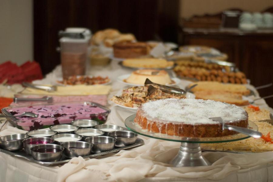 坎皮纳斯马里亚诺皇宫酒店的一张桌子,上面放着许多不同类型的蛋糕和馅饼