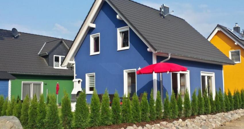 马林费尔德Ferienhaus Strandräuber的前面有红伞的蓝色房子