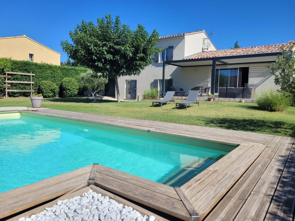 艾居厄河畔卡马勒Villa de la Capèra的一个带游泳池和房子的后院