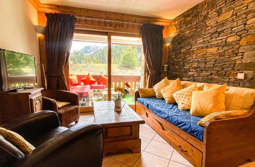 美贝尔SkiMottaret的带沙发和石墙的客厅