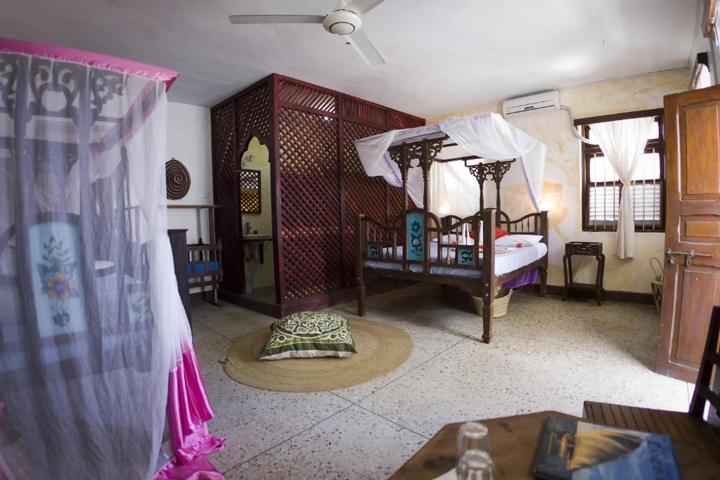 桑给巴尔Zenji Hotel的客房设有带床和窗帘的卧室。