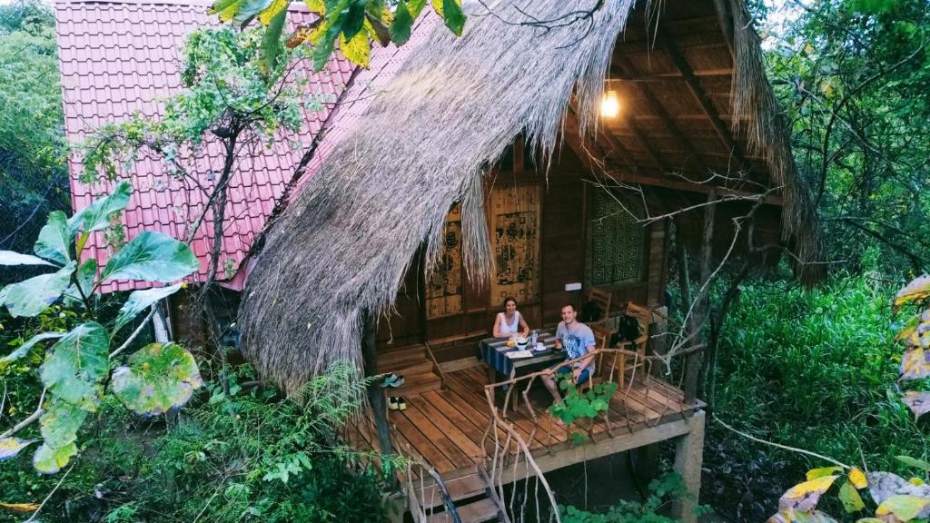 哈伯勒内Habarana Tree House Ambasewana Resort的两个人坐在房子的甲板上