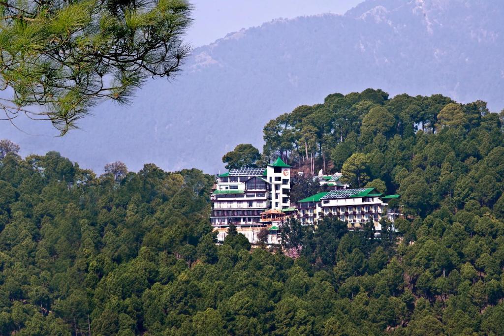 麦罗肯机Fortune Park Moksha, Mcleod Ganj - Member ITC's Hotel Group的森林中间的一座小山上的建筑