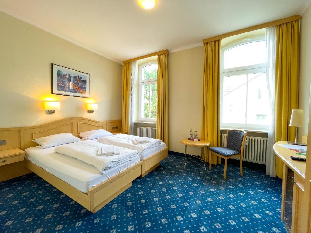 雷根斯堡Bischofshof Braustuben的酒店客房带一张大床和一把椅子