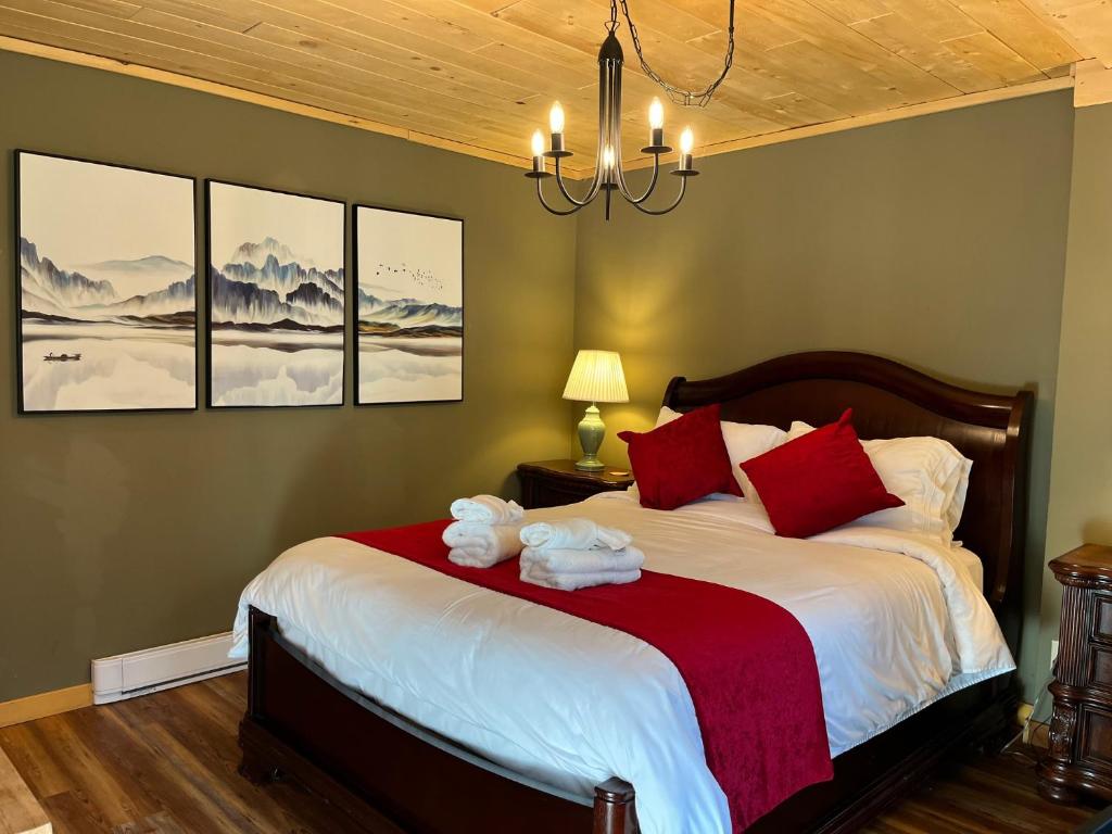 Port AliceFrigon Suite -Waterfront的一间卧室配有一张带红色枕头的大床