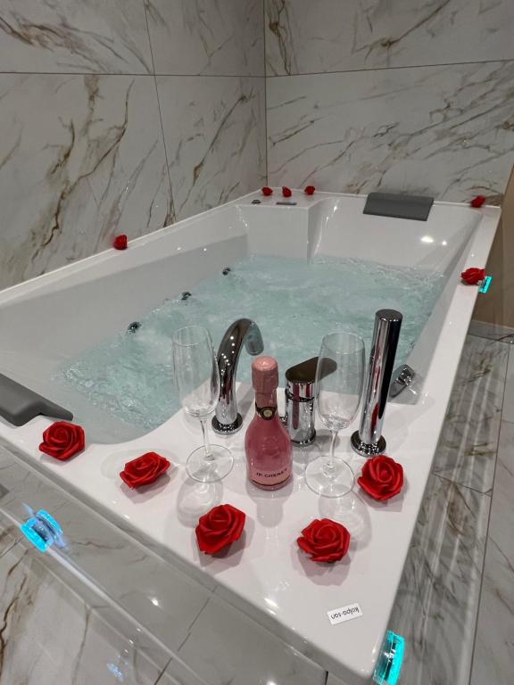 皮兰Diamond Apartment Piran FREE PARKING的浴室配有带酒杯和玫瑰的浴缸