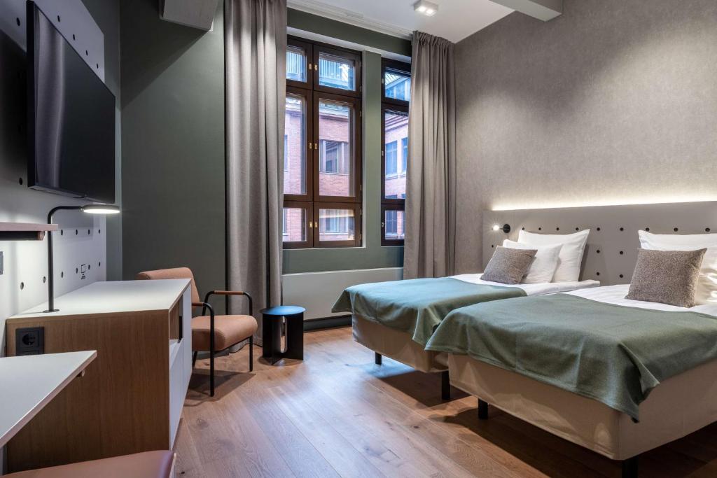 赫尔辛基Scandic Helsinki Hub的一间酒店客房,设有两张床和电视