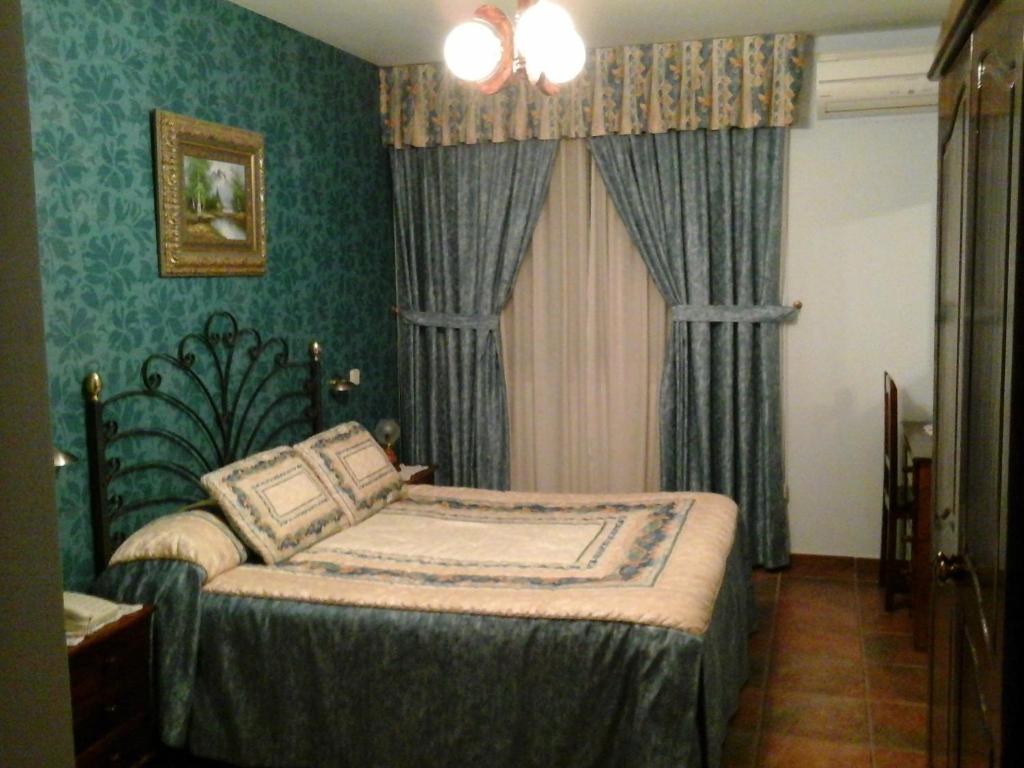 Vega de EspinaredaHostal Piñera的一间设有床铺的卧室,位于一个拥有绿色墙壁的房间