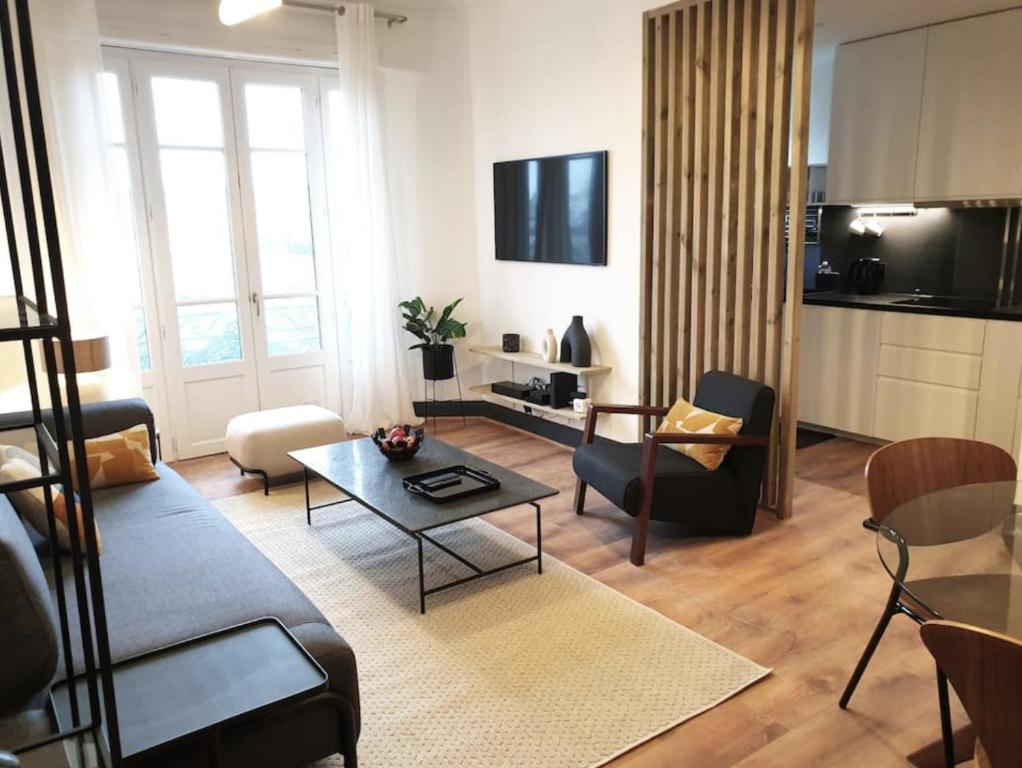 维希Vichy : Le 5e - Appartement design dans un ancien palace的客厅配有沙发和桌子