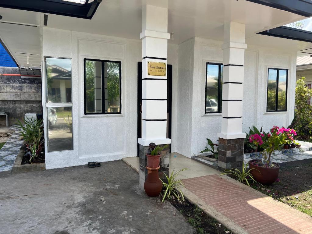 达沃市Davao Transient Villa with 24hrs security guard BBQ Grill , Free Parking and Wifi的前面有植物的白色房子