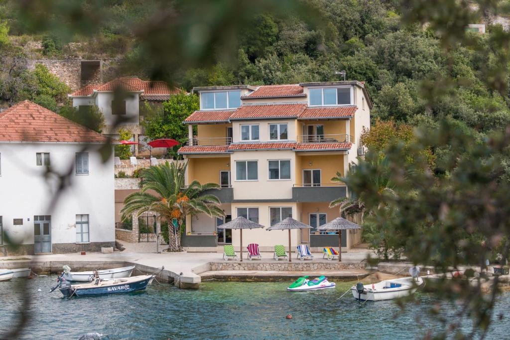 布里尼Apartments by the sea Savar, Dugi otok - 8128的水面上的房子,前面有船