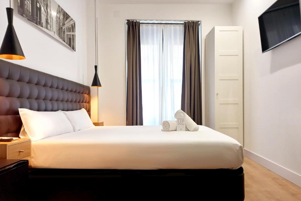 马德里丘埃卡惊喜客房民宿 的一间卧室设有一张大床和一个窗户。