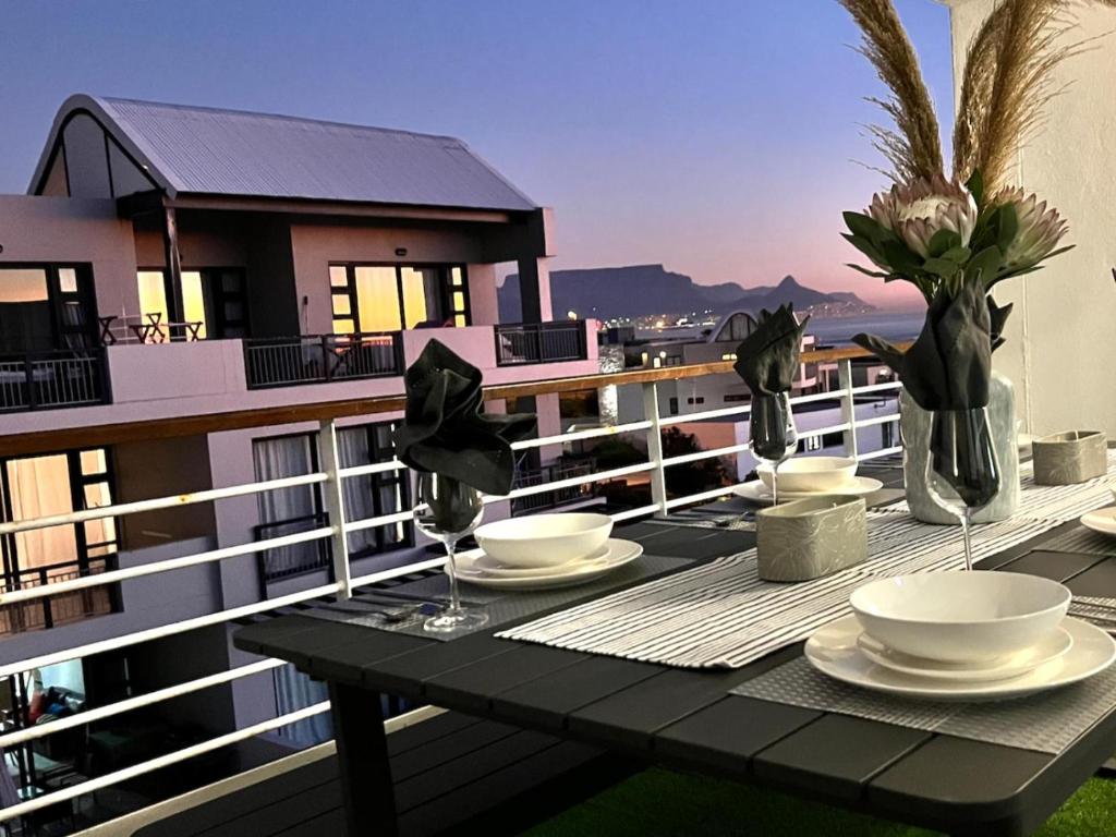 比格湾Azure 213-Luxury 2 Bedroom Apartment with an Inverter & Battery Backup Power的阳台上的桌子上摆放着盘子和碗