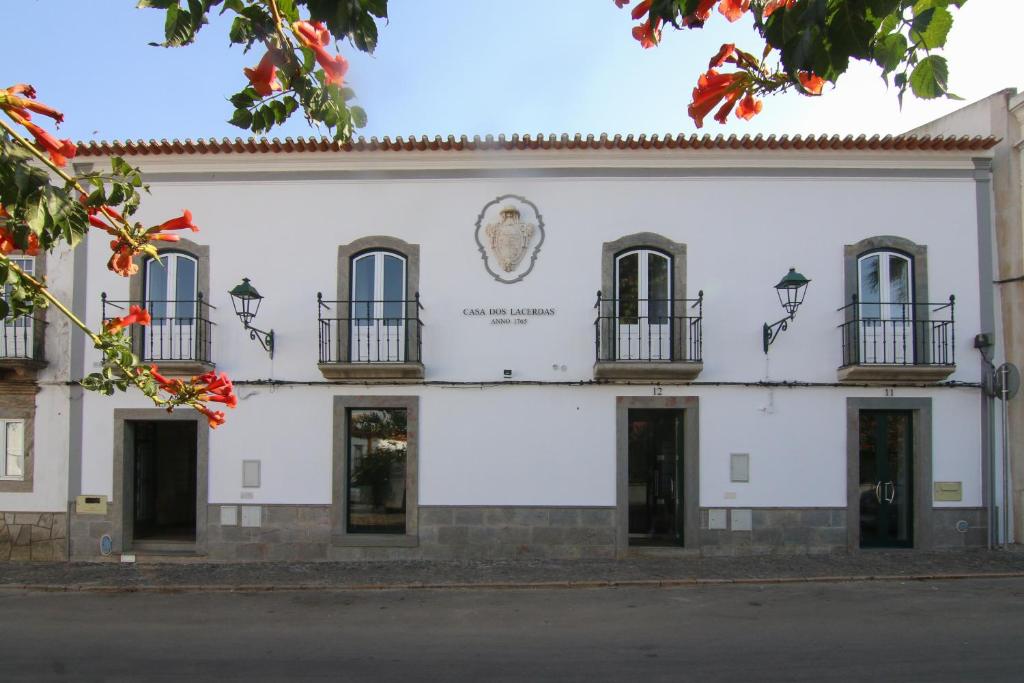 莫朗Casa dos Lacerdas的一座白色的建筑,旁边设有雕像