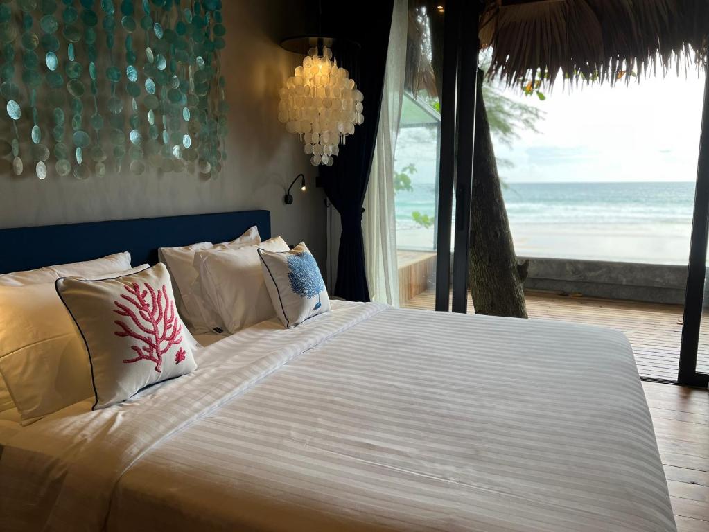 奈通海滩Sealord Naithon Beachfront Villa的一间卧室设有一张床,享有海景