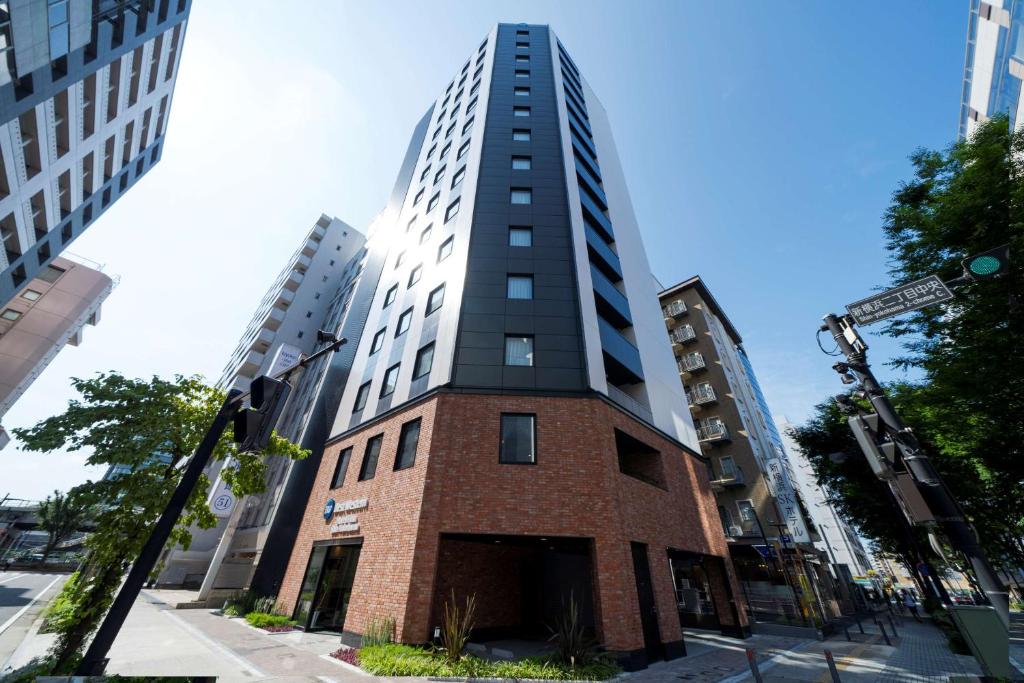 横滨Best Western Hotel Fino Shin-Yokohama的城市街道上一座高大的砖砌建筑