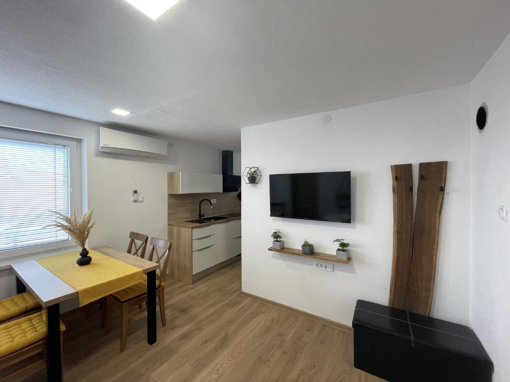 采尔克诺Apartments and rooms pri Bašlju的厨房以及带桌子和电视的用餐室。