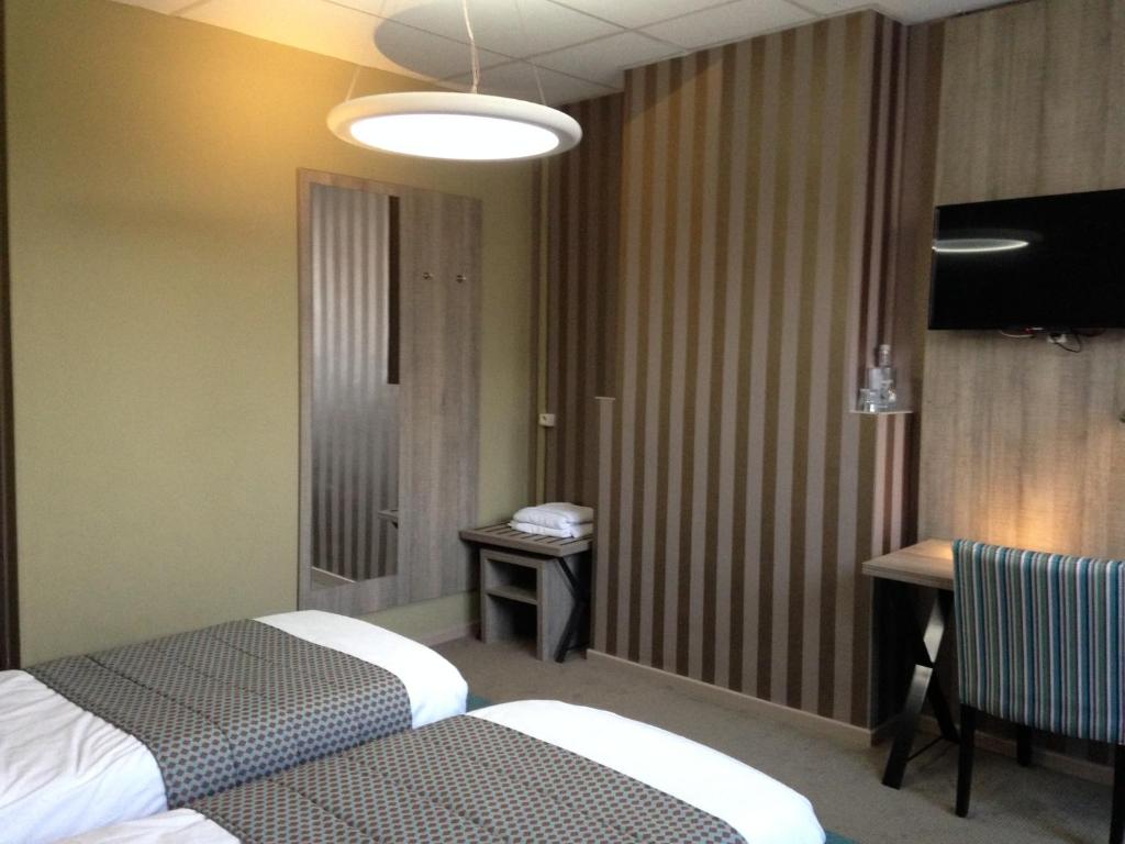 鲁汶米勒克隆酒店的酒店客房设有两张床和一张桌子。