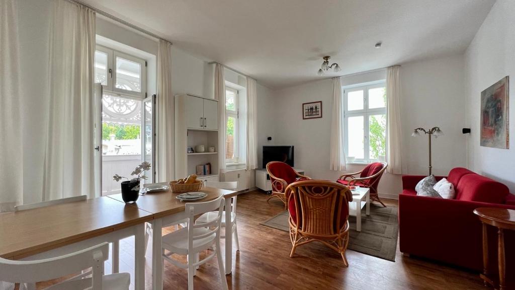 奥斯赛拜-塞林Villa Sonneck – Wohnung 15的厨房以及带桌椅的起居室。