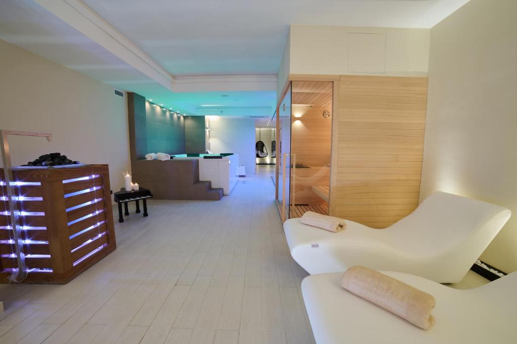 博尔塞纳Ludwig Boutique Hotel & Spa的一间带白色沙发的客厅和一间浴室