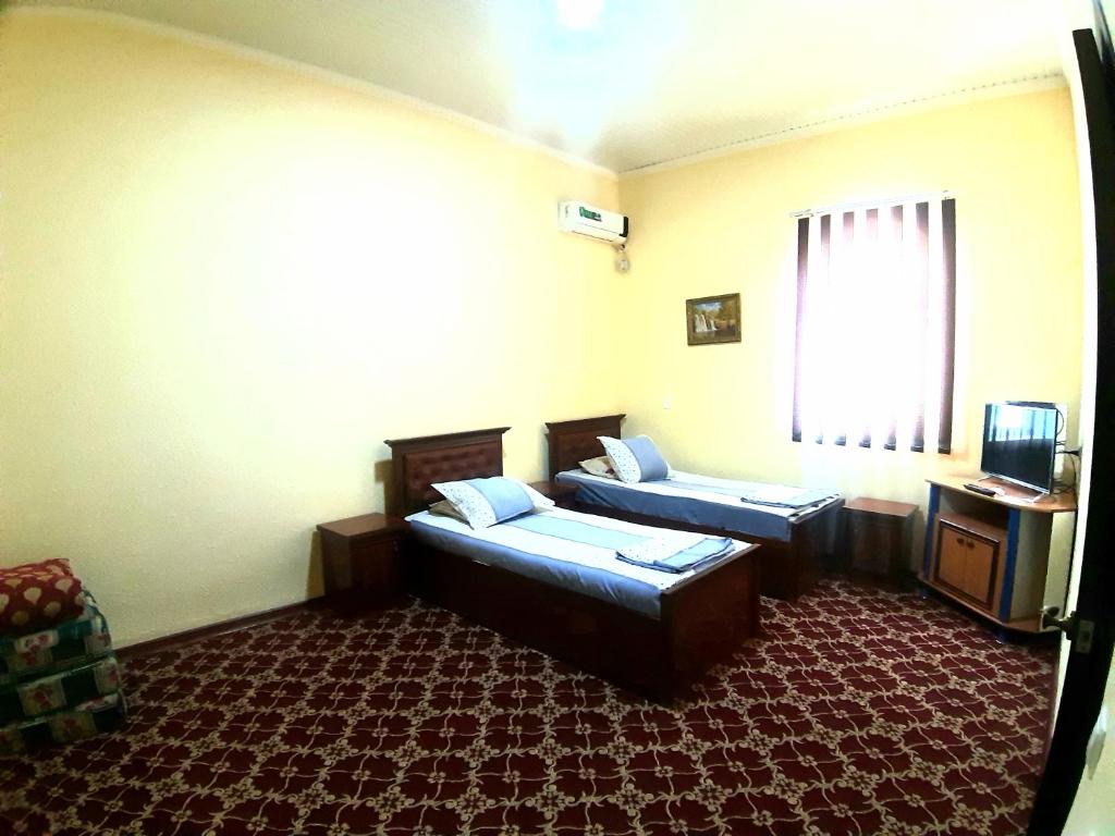 希瓦Khiva Indi Guest House的酒店客房设有两张床和窗户。