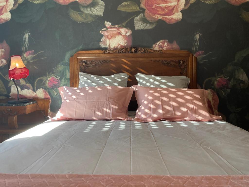 罗德兹Chez Paul et Louis的一间卧室配有一张带花卉壁纸的床