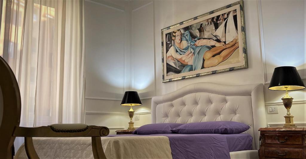 罗马国王广场住宿加早餐旅馆的卧室配有一张床,墙上挂有绘画作品
