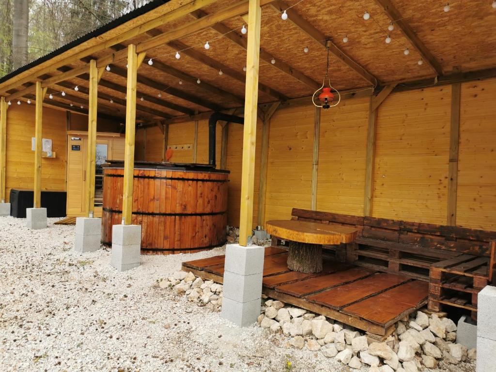 齐尔茨Déjá Vu Szállás & Rendezvény Zirc的木制凉亭,配有木凳和桌子
