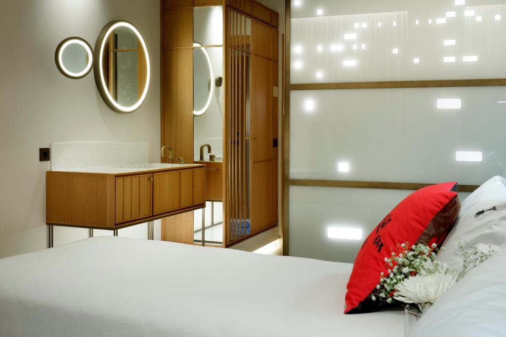 马德里Hard Rock Hotel Madrid的一间卧室配有一张红色枕头的床和一间浴室