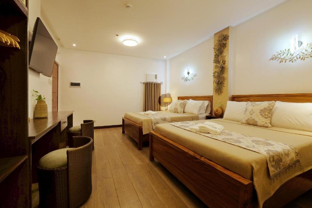 科隆Jai-cob’s Suites的酒店客房设有两张床和电视。
