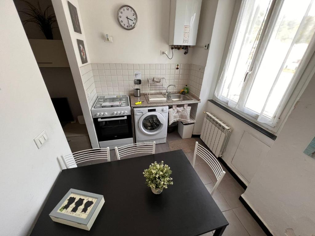热那亚Appartamento Low-cost Fillak的厨房配有桌子、水槽和炉灶。