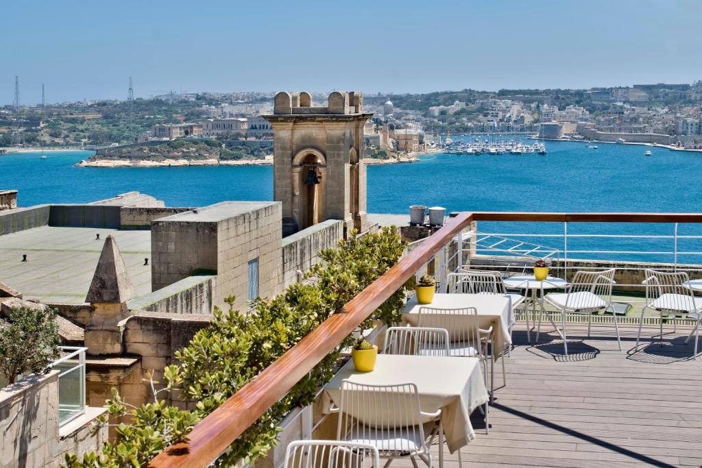 瓦莱塔Ursulino Valletta的阳台配有桌椅,享有水景。