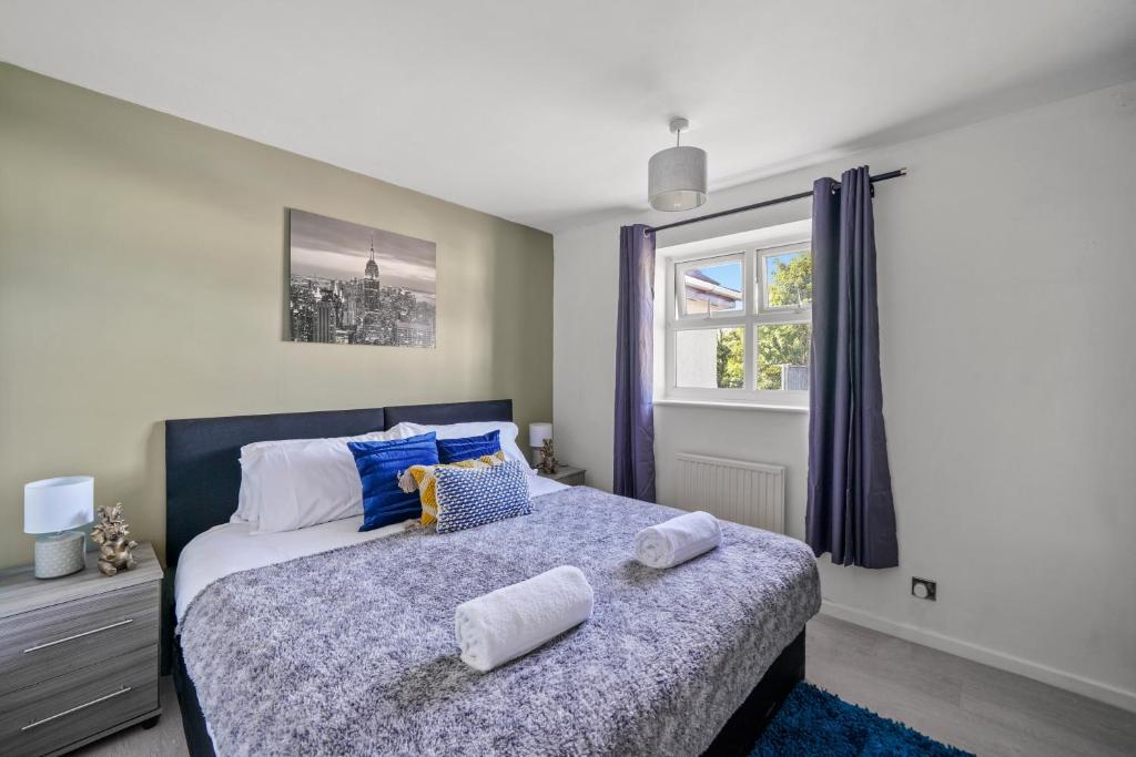 纽尼顿BridgeCity Cheerful 3 bedroom home in Nuneaton的一间卧室配有一张床,上面有两条毛巾