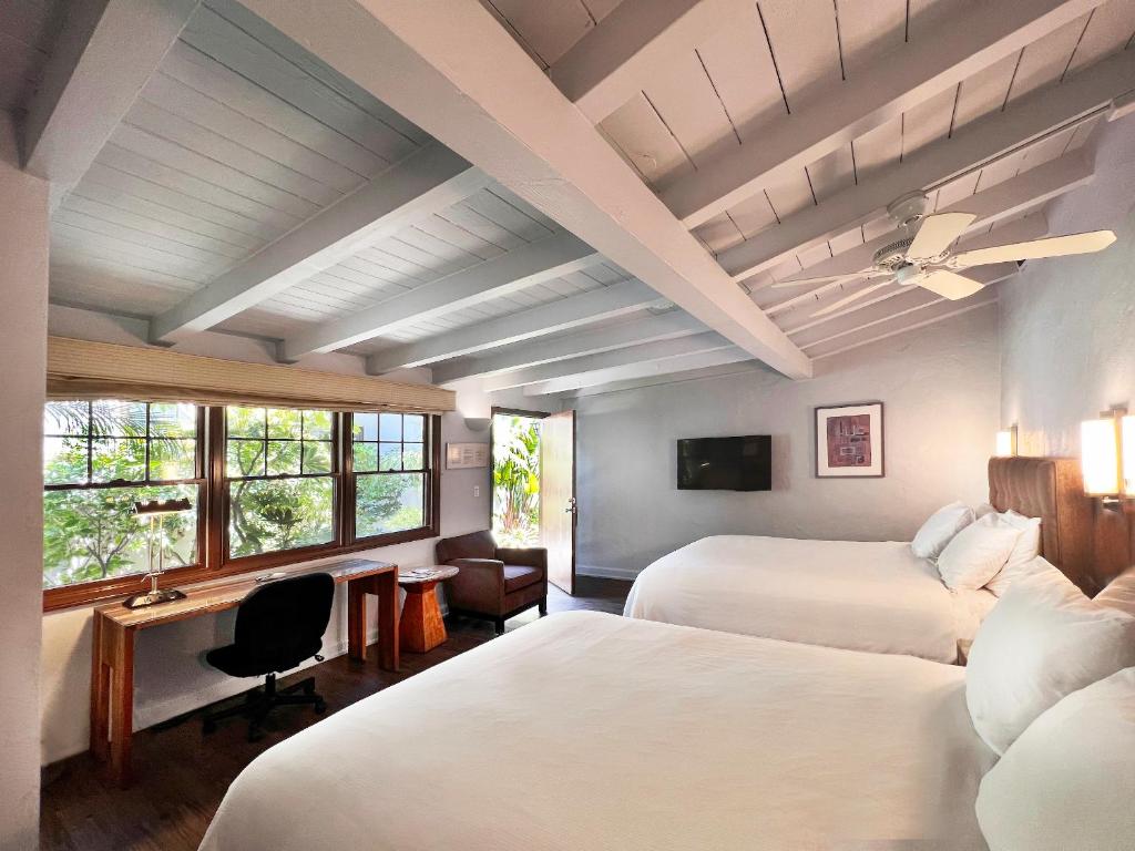 圣巴巴拉卡萨德尔玛酒店的一间卧室配有两张床、一张桌子和一台电视。