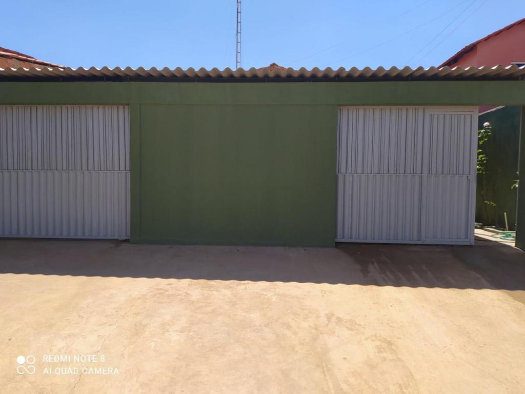 戈亚斯州上帕莱索Recanto da Chapada的两扇车库门位于带车道的绿色建筑中